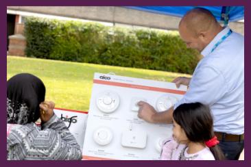 A Fire Safety Manager presenting different types of Fire Alarms to residents.